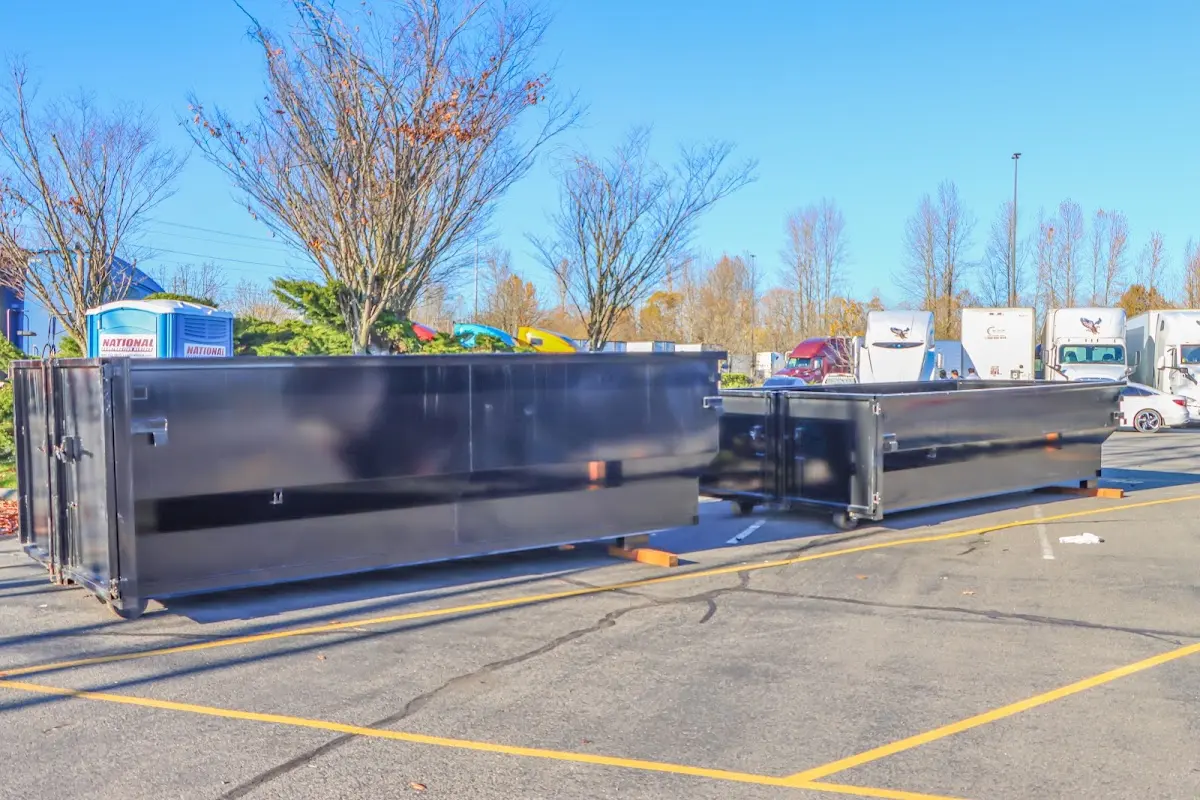 Professional dumpster rental service with roll-off container on residential driveway in Grass Lake